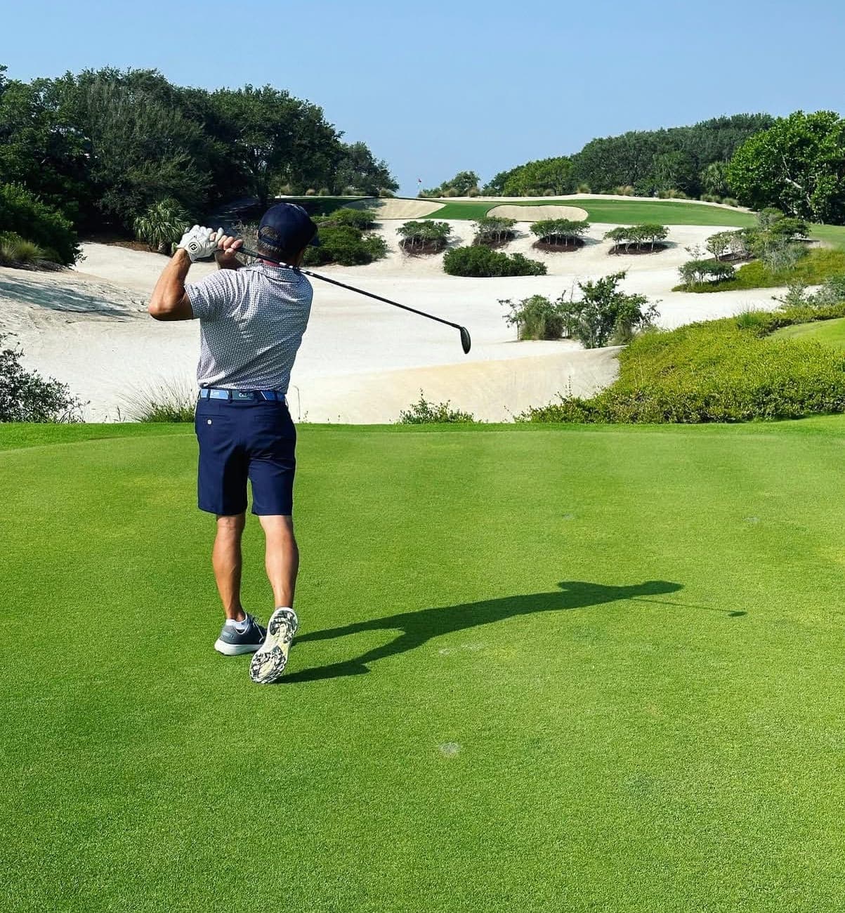 Alex Haigh swinging a golf club on the course